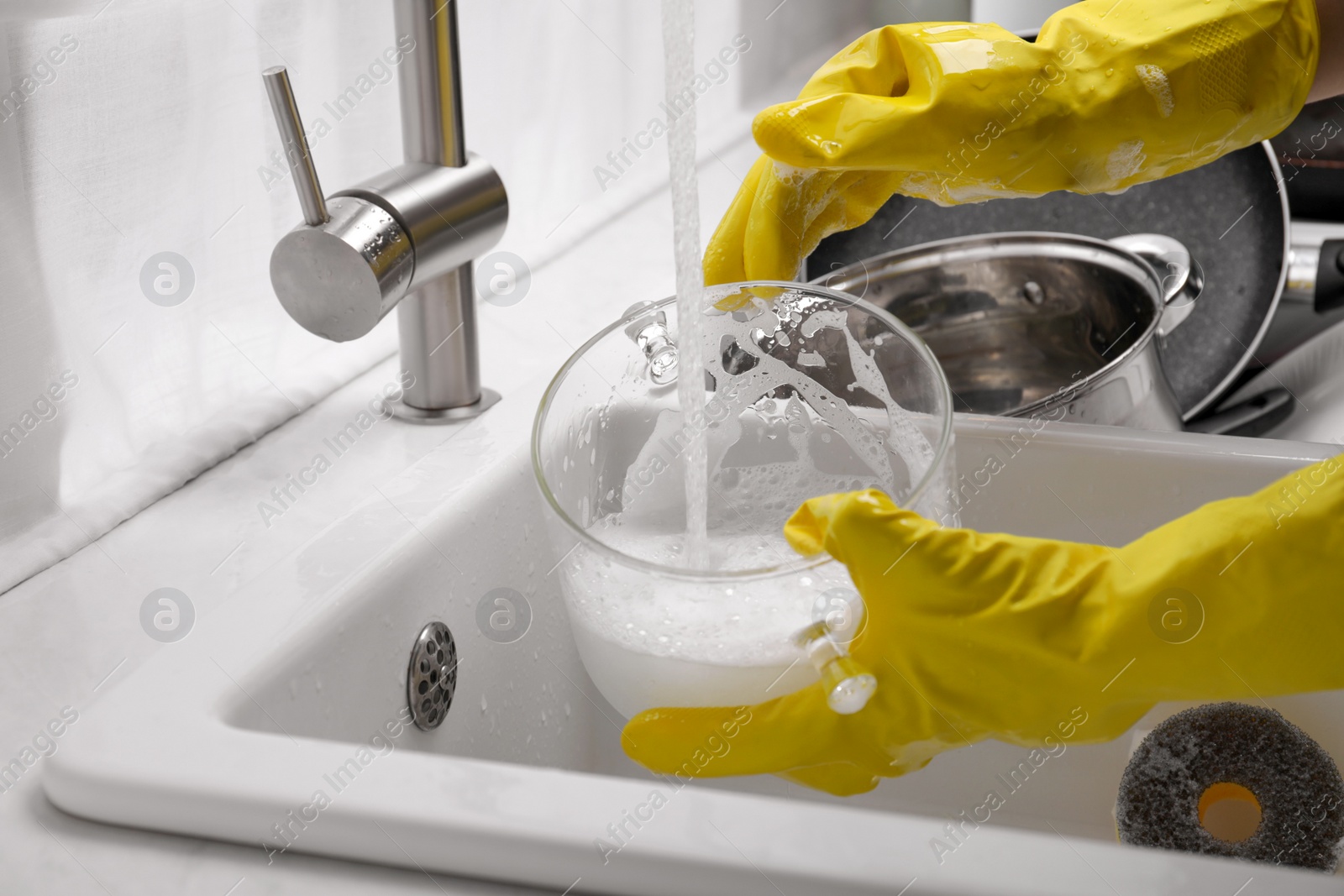 Photo of Woman washing glass pot in kitchen sink, closeup