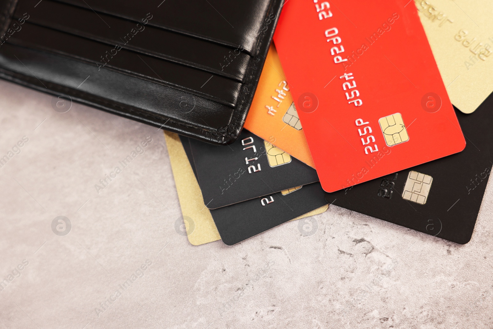 Photo of Many different credit cards and leather wallet on grey table, top view