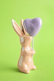 Photo of Bunny ceramic figure as Easter decor on green background