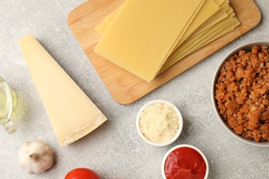 Photo of Flat lay composition with products for cooking lasagna on grey textured table
