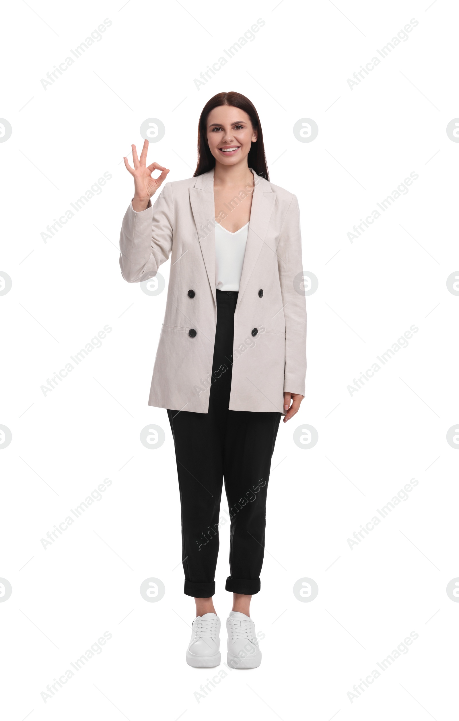 Photo of Beautiful businesswoman in suit showing OK gesture on white background