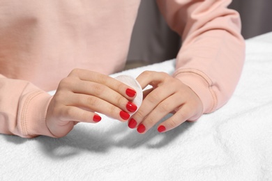Photo of Woman removing nail polish at table, closeup