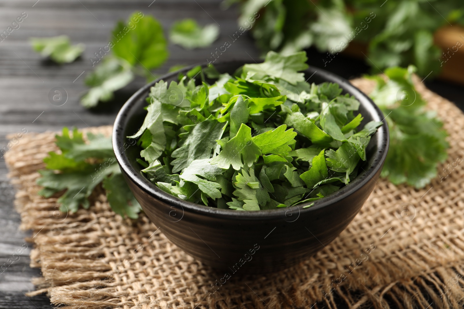 Photo of Cut fresh green cilantro in bowl on table, closeup