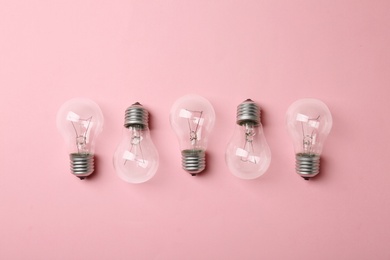 Photo of New incandescent lamp bulbs on pink background, top view