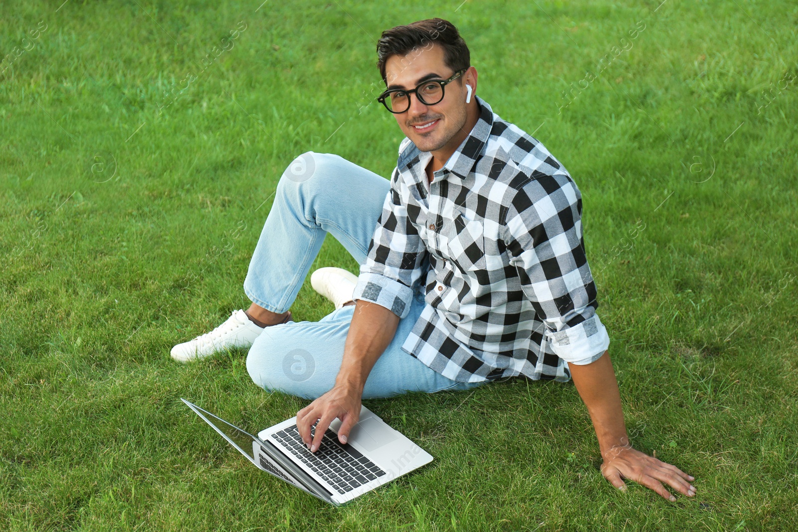 Photo of Portrait of young man with laptop outdoors