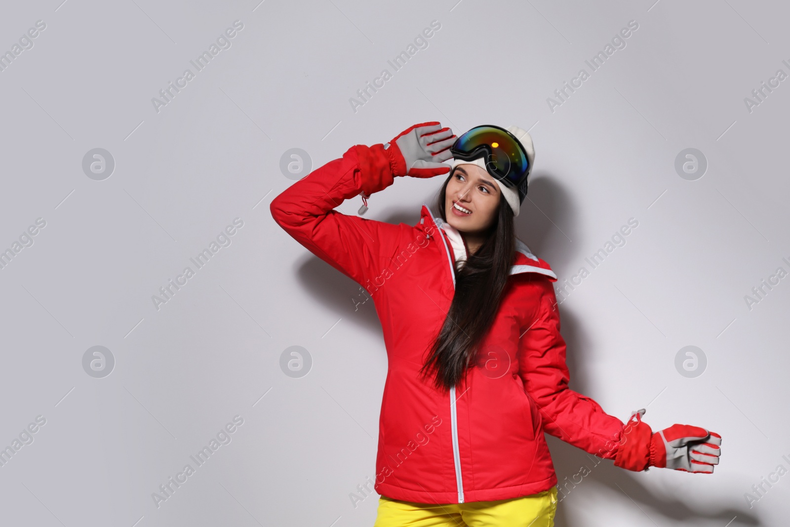 Photo of Woman wearing stylish winter sport clothes on light grey background