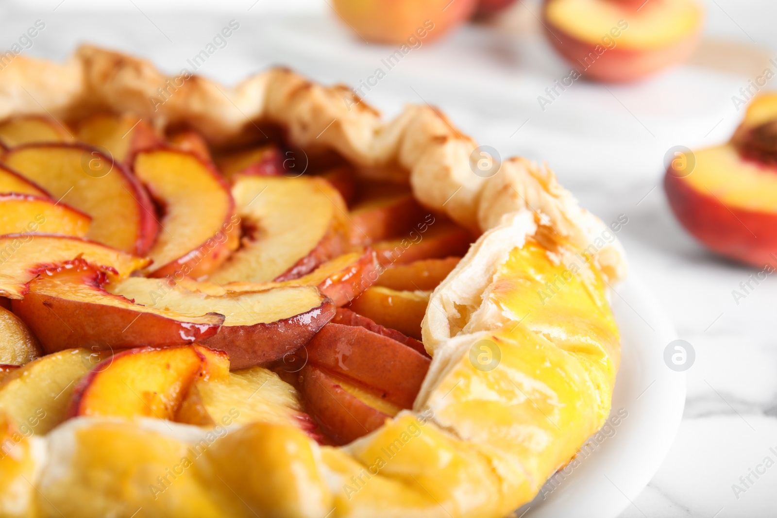 Photo of Delicious fresh peach pie on white table, closeup