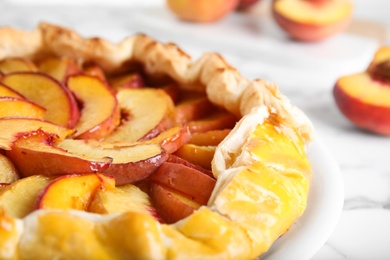 Delicious fresh peach pie on white table, closeup