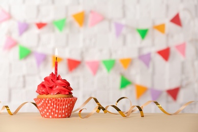 Photo of Birthday cupcake with candle against blurred background