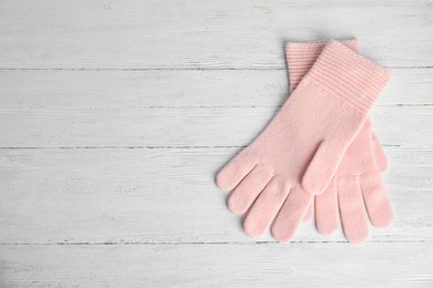 Photo of Stylish pink gloves on white wooden background, top view with space for text. Autumn clothes