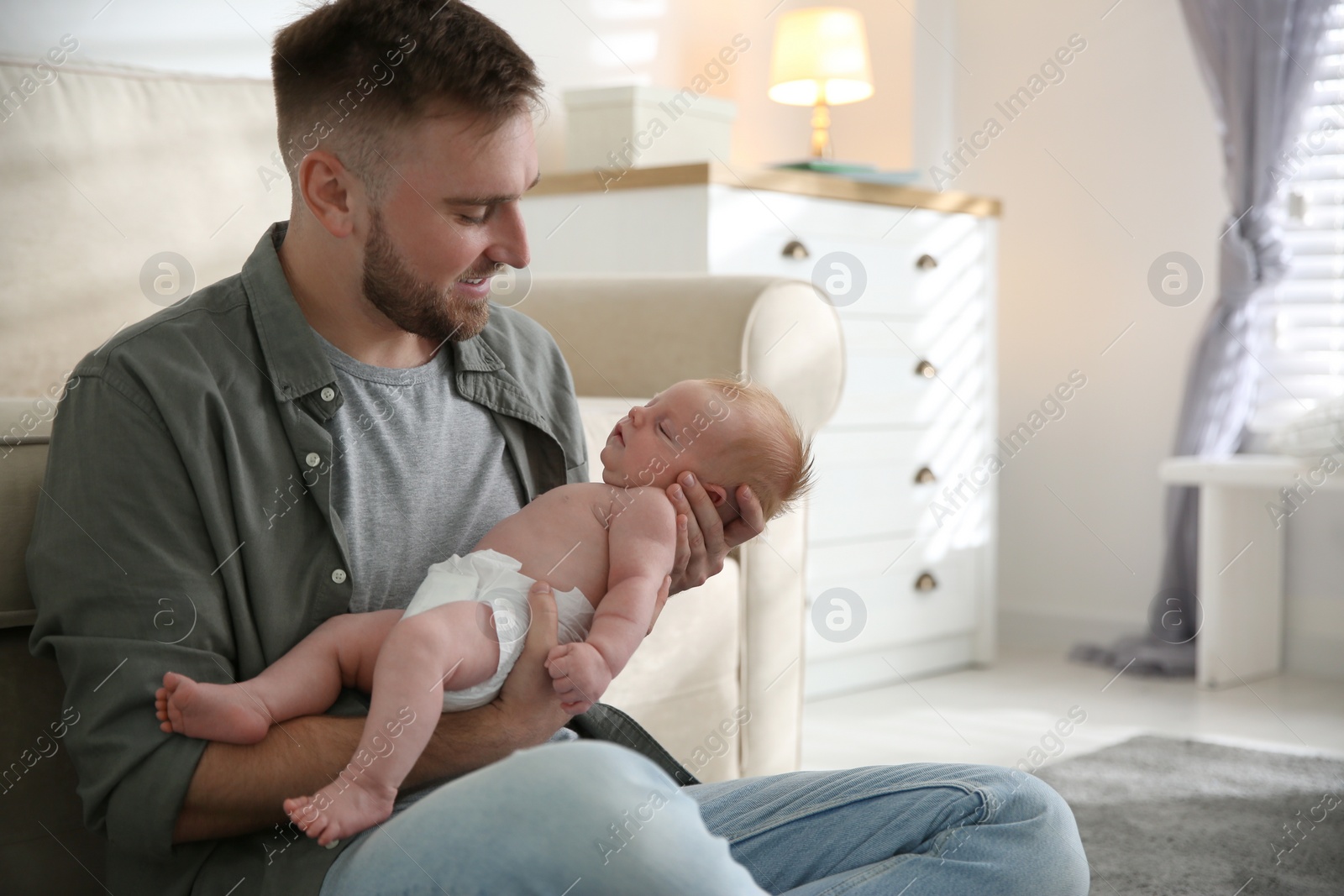 Photo of Father with his newborn son at home