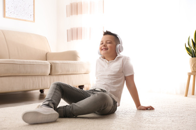 Little boy listening to music on floor at home