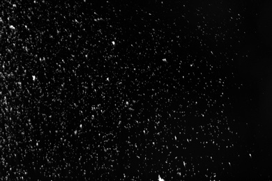 Snow flakes falling on black background. Winter weather