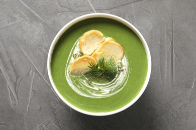 Photo of Fresh vegetable detox soup with croutons in dish on table, top view