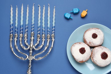 Flat lay composition with Hanukkah menorah on blue background