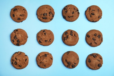 Delicious chocolate chip cookies on color background, flat lay