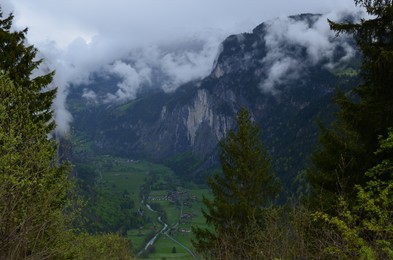 Photo of Picturesque view of village in high mountains covered with fog