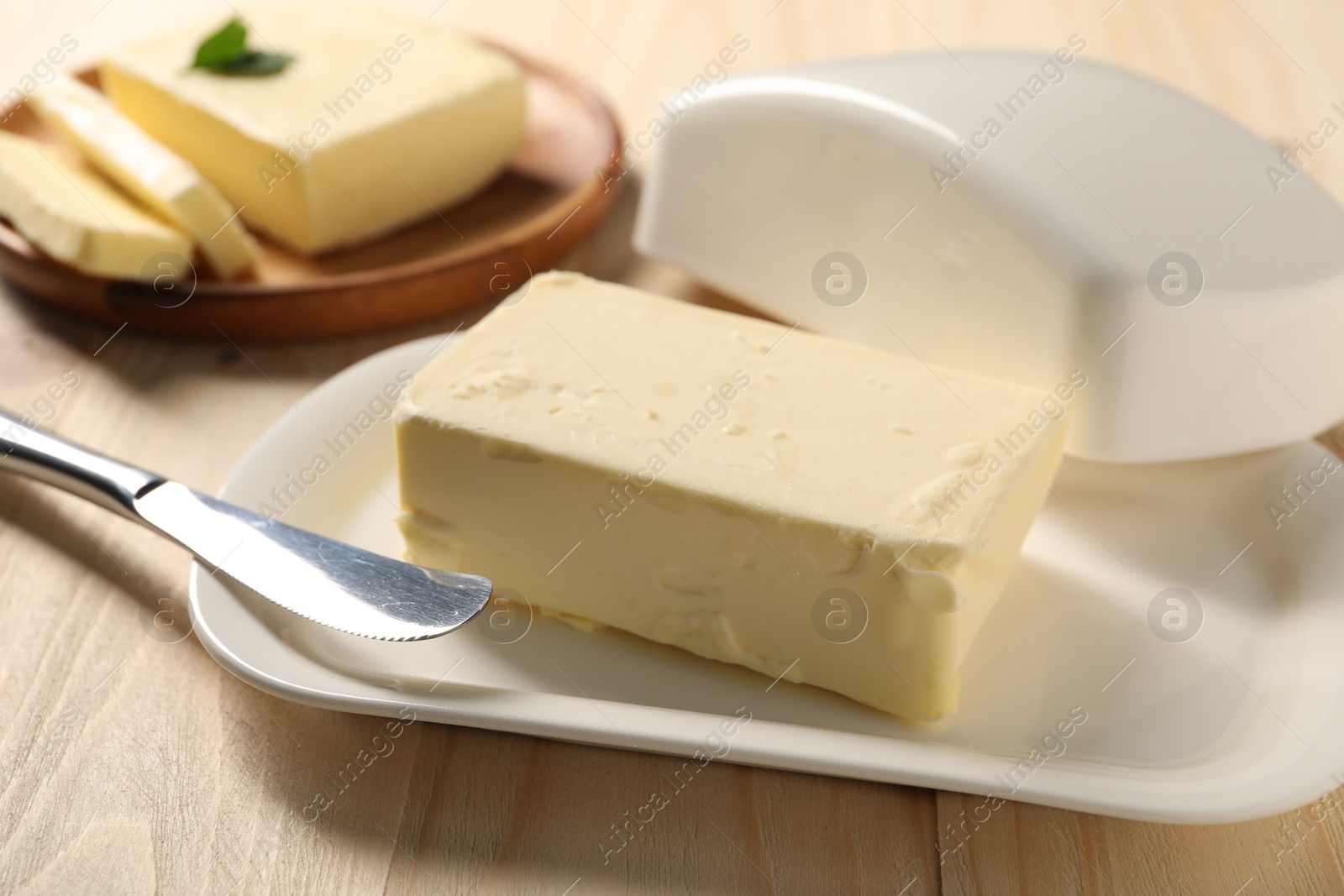 Photo of Tasty butter and knife on wooden table