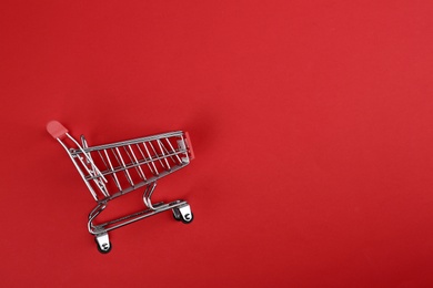 Photo of Empty shopping trolley on color background, top view. Space for text