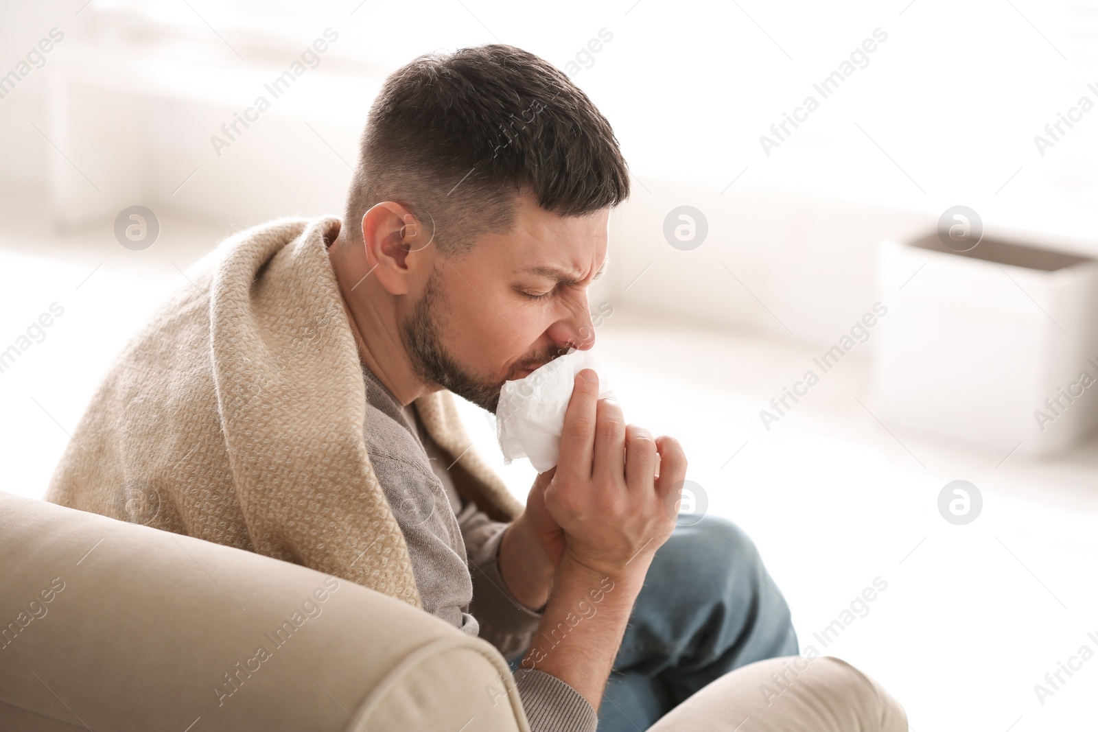 Photo of Man suffering from runny nose at home