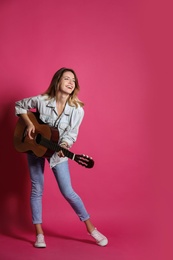 Photo of Young woman playing acoustic guitar on color background