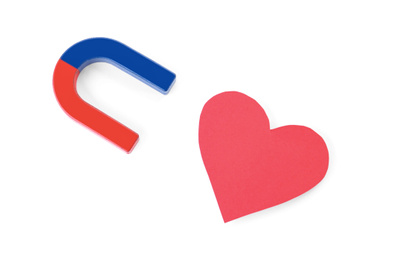 Red and blue horseshoe magnet and paper heart on white background, top view