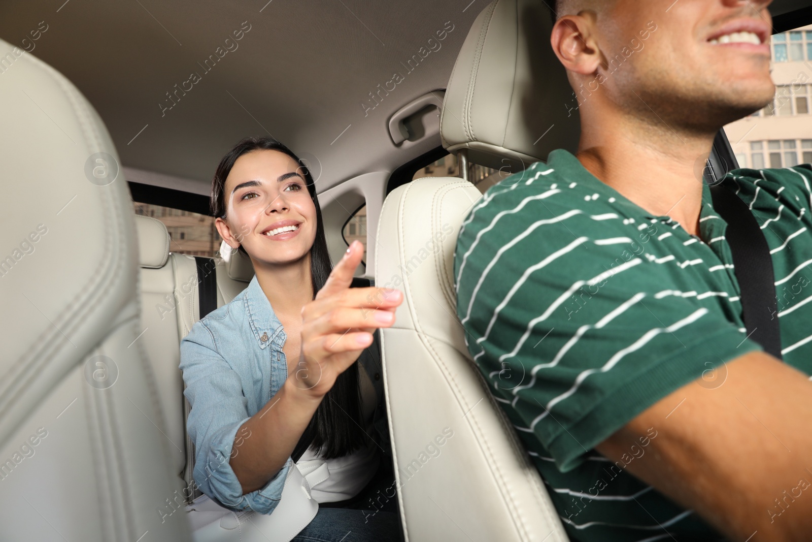 Photo of Young woman and taxi driver in modern car