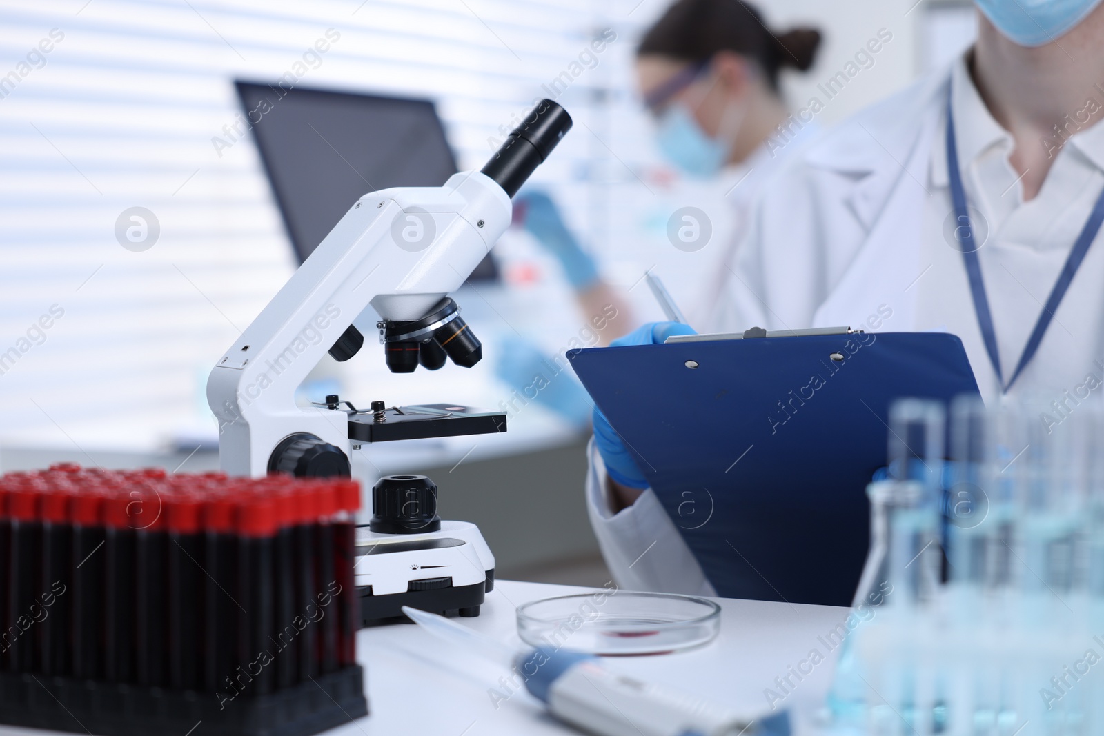 Photo of Scientist working with laboratory test form at table indoors, closeup