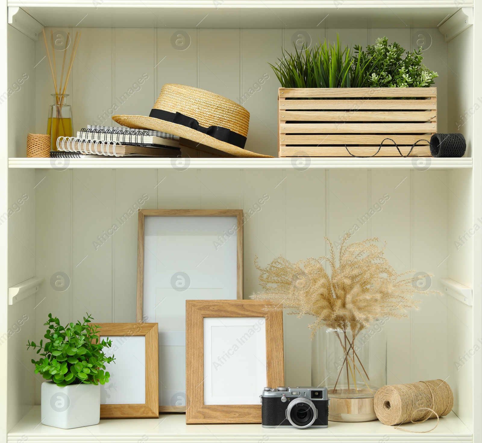 Photo of White shelving unit with different decorative elements