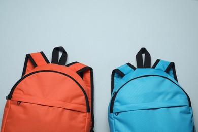 Photo of Stylish backpacks on light grey background, flat lay
