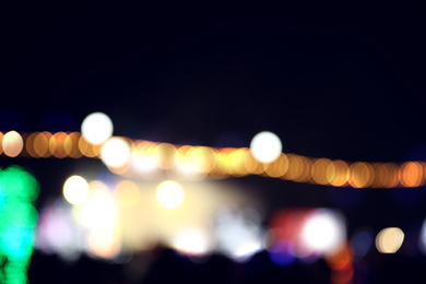 Photo of Blurred view of city street with festive lights at night. Bokeh effect