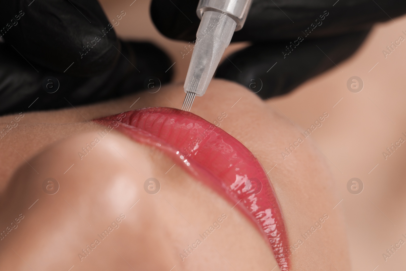 Photo of Young woman during procedure of permanent lip makeup in beauty salon, closeup