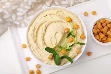 Photo of Delicious hummus with chickpeas served on white table, flat lay