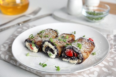 Photo of Delicious baked eggplant rolls served on white table