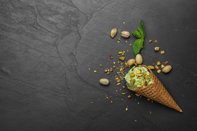 Photo of Delicious pistachio ice cream on dark table, flat lay. Space for text