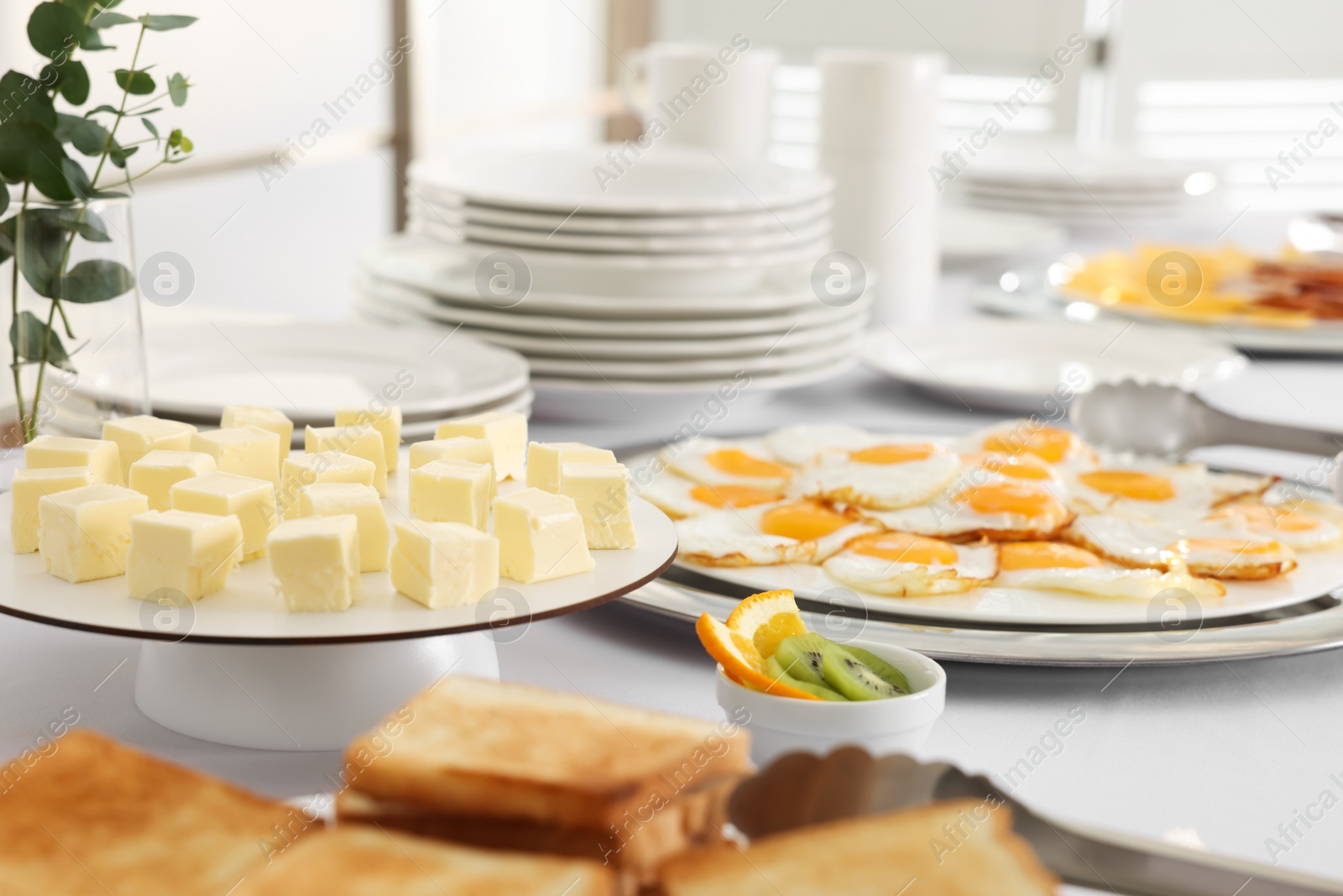 Photo of Clean dishware and different meals for breakfast on white table indoors. Buffet service