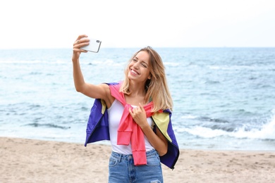 Attractive woman taking selfie on sea coast