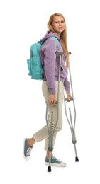 Young woman with axillary crutches on white background