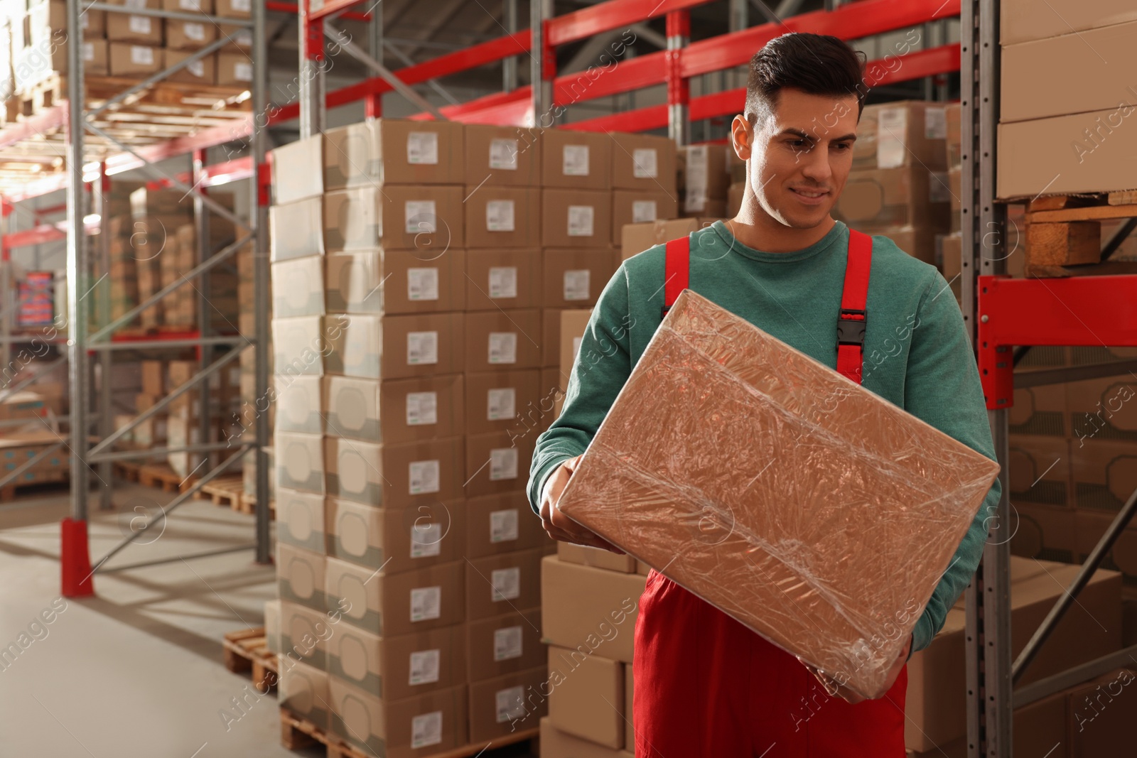 Photo of Worker with cardboard box in warehouse, space for text. Wholesaling