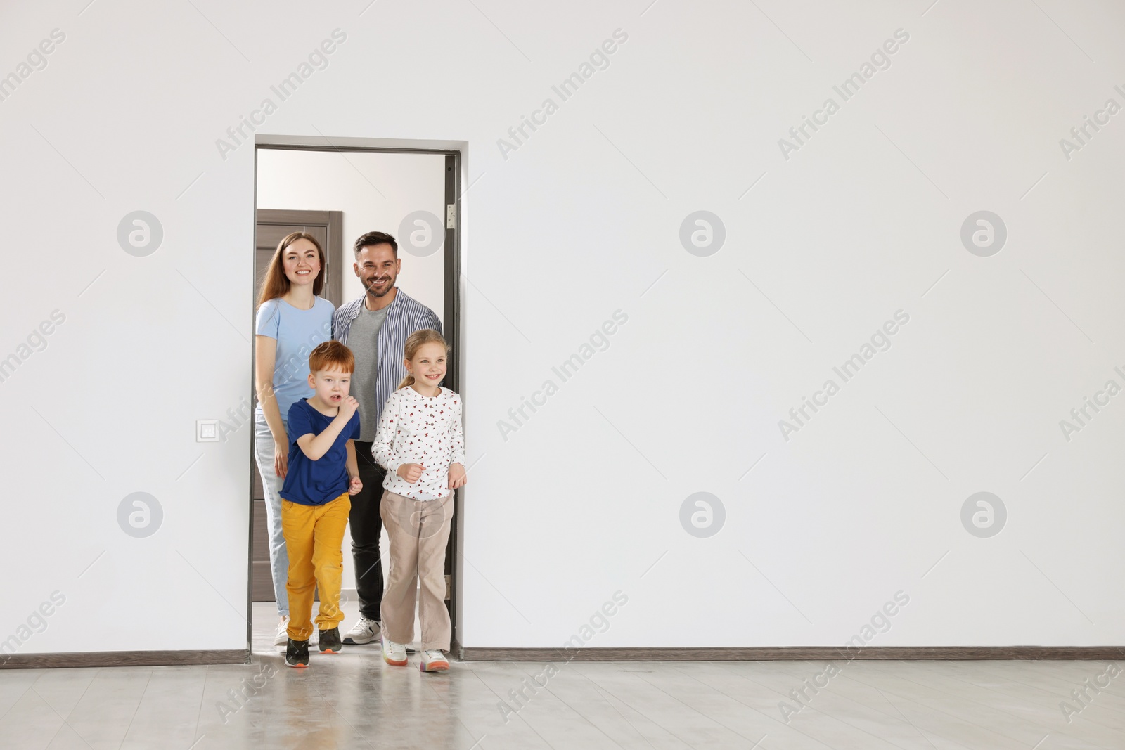 Photo of Happy family entering in their new apartment on moving day. Space for text