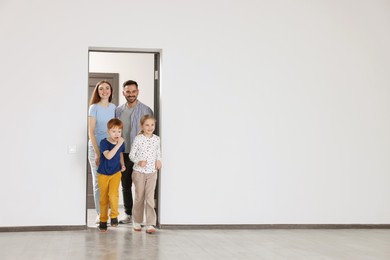 Photo of Happy family entering in their new apartment on moving day. Space for text