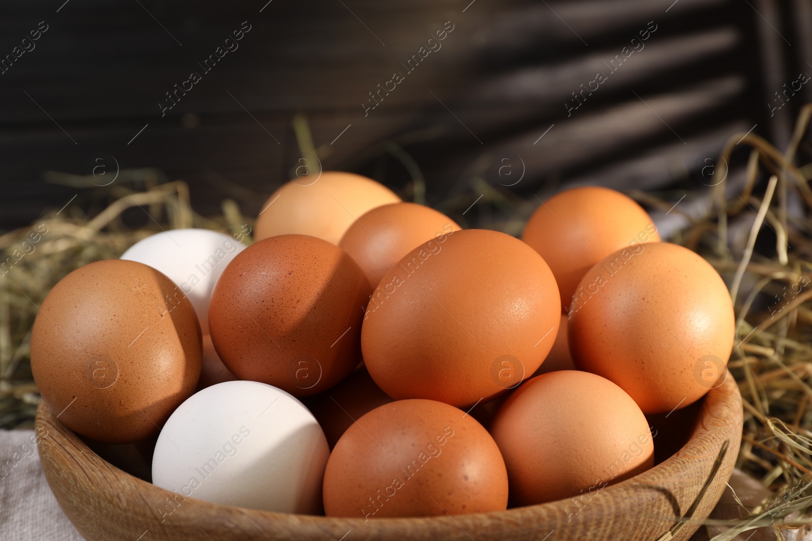 Photo of Fresh chicken eggs in bowl on table, closeup