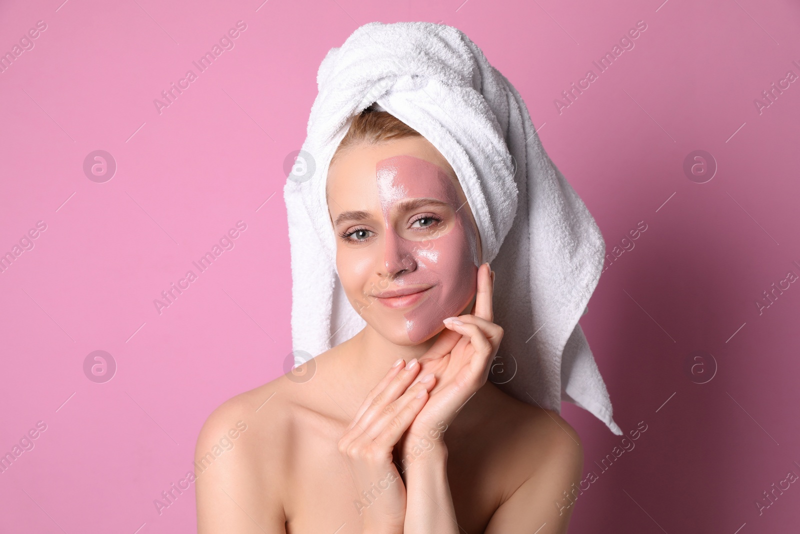 Photo of Young woman with pomegranate face mask on pink background