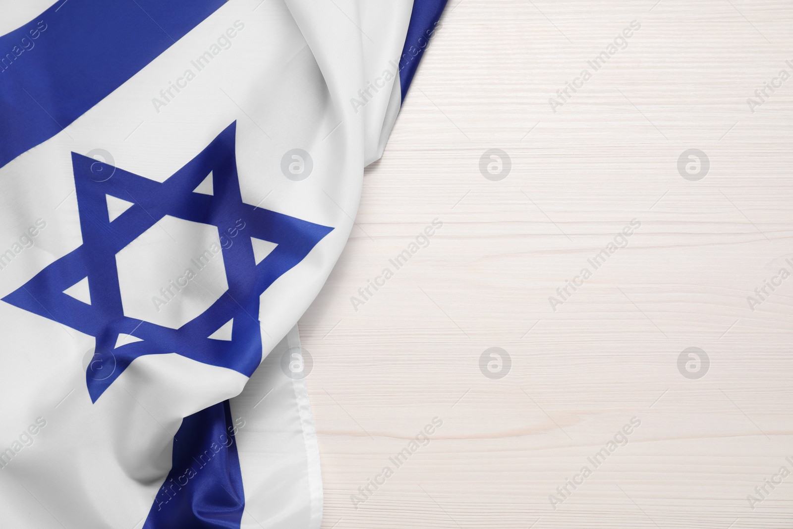 Photo of Flag of Israel on white wooden background, top view and space for text. National symbol