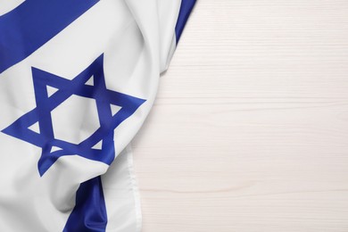 Photo of Flag of Israel on white wooden background, top view and space for text. National symbol