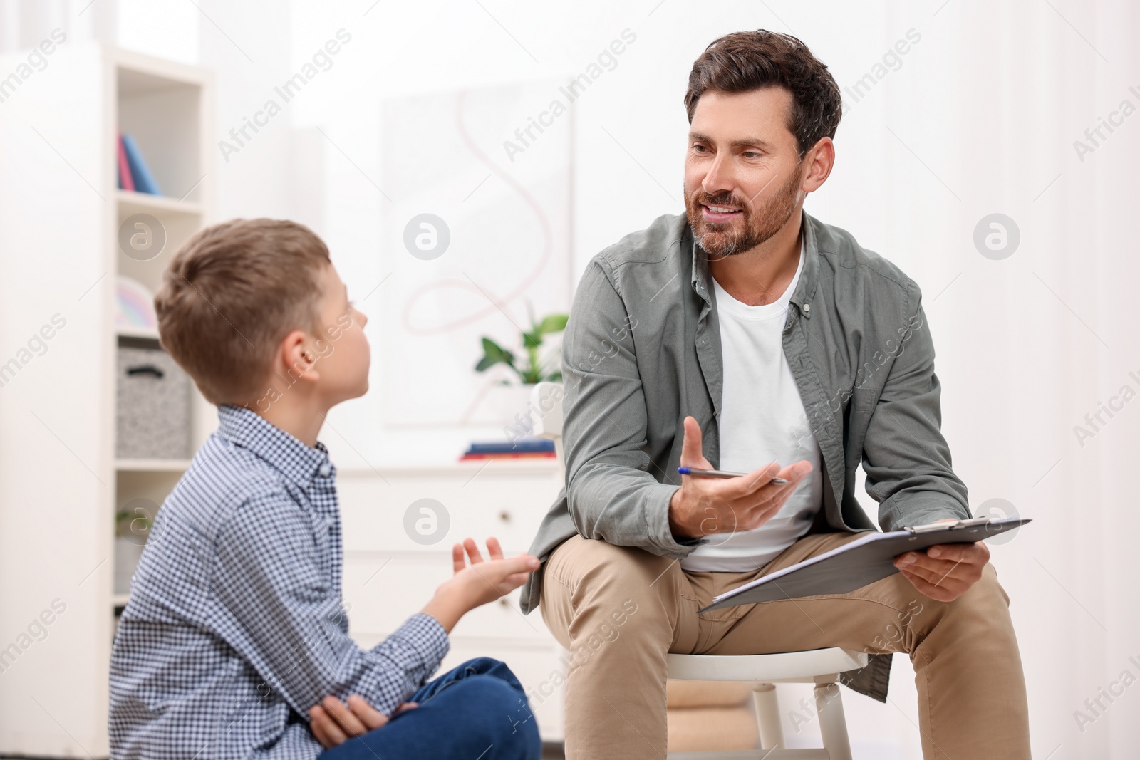 Photo of Dyslexia treatment. Therapist working with boy in room