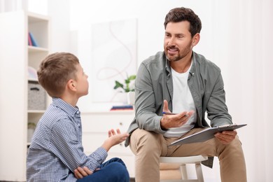 Dyslexia treatment. Therapist working with boy in room