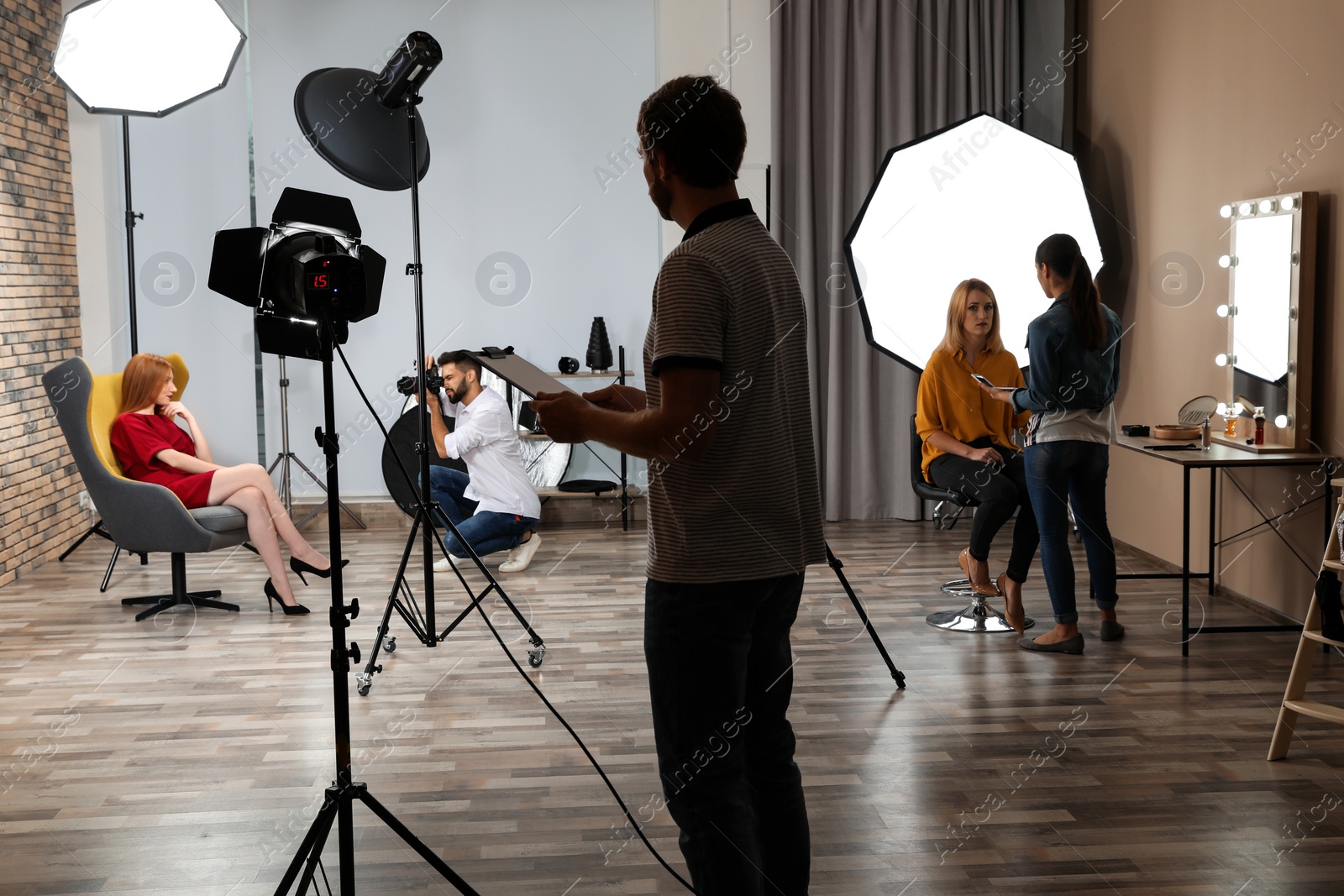 Photo of Photo studio with professional equipment and team of workers