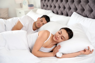Lovely couple sleeping in large comfortable bed