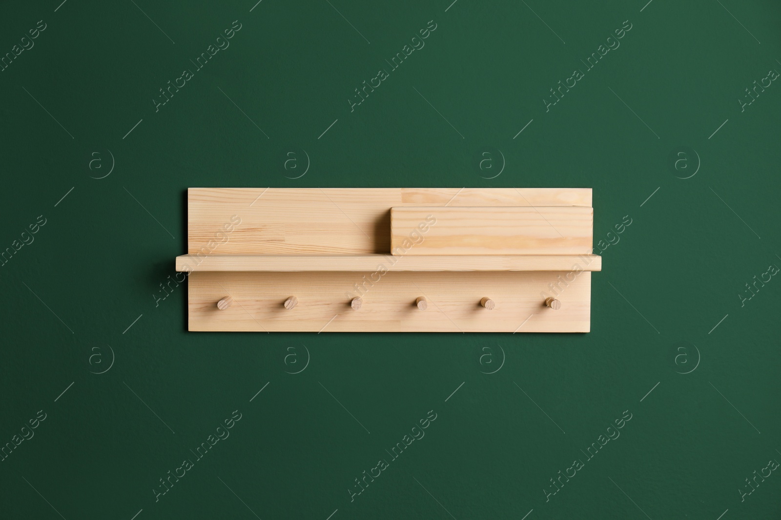 Photo of Wooden hanger for keys on green wall